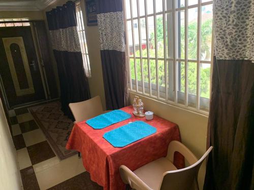 une table avec un chiffon de table rouge et des serviettes bleues dans l'établissement Apartment For Short and Long Stay, à Accra