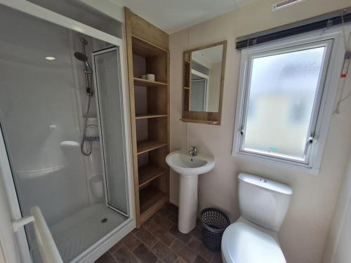a bathroom with a shower and a toilet and a sink at 3 Bedroom Deluxe Caravan at Haven Devon Cliffs in Exmouth