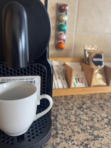 a coffee maker with a cup of coffee on a counter at Wanderlust House in Ponta Delgada
