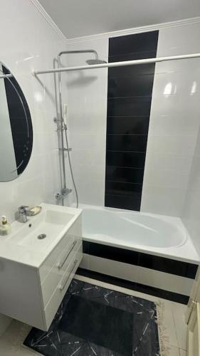 a white bathroom with a sink and a mirror at Apartment for rent in Căușeni 2 in Căuşeni