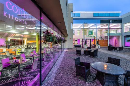 un restaurante con mesas y sillas en un edificio en Holiday Inn Sittingbourne, an IHG Hotel, en Sittingbourne