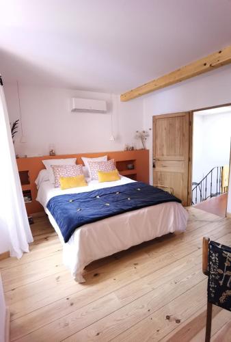 - une chambre dotée d'un grand lit avec des draps bleus et des oreillers jaunes dans l'établissement Le 42 escapade en Provence - Petit déjeuner en option, à Montfort-sur-Argens