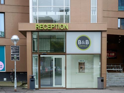 a store front with a sign that reads reception at B&B HOTEL Vejle in Vejle
