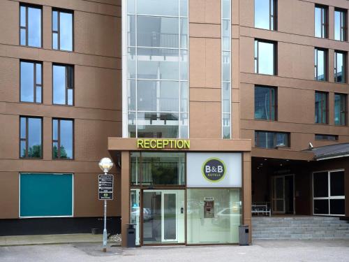 a facade of a building with a sign that reads reception at B&B HOTEL Vejle in Vejle