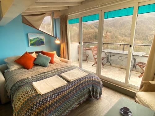 1 Schlafzimmer mit einem Bett und einem Balkon mit einem Tisch in der Unterkunft Tuscany Home-Casoli in Casoli