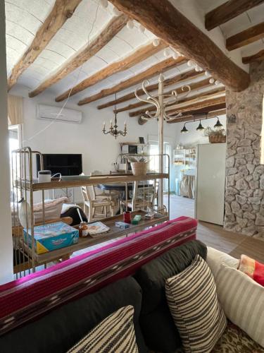 ein Wohnzimmer mit einem Sofa und einem Tisch in der Unterkunft El Mirador de Benialfaqui, apartamento Els Olivers 