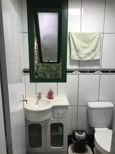 bagno con lavandino, specchio e servizi igienici di Cabana parque ad Antônio Prado