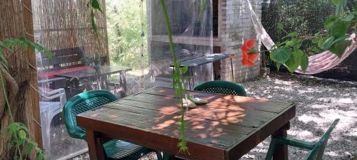 a wooden table with chairs and a hammock in a backyard at Gotas de Rocio in Piriápolis