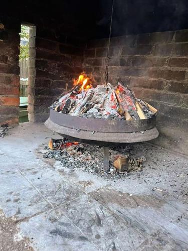a fire in a brick oven with a wheel at 7Pines Bijambare - Air Spa in Sarajevo