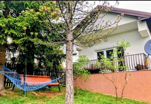 a blue hammock in front of a house at 7Pines Bijambare - Air Spa in Sarajevo