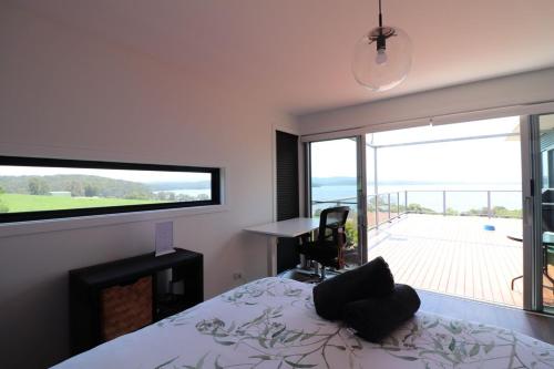 a bedroom with a bed and a view of a patio at 4 Scenic Court in Mallacoota