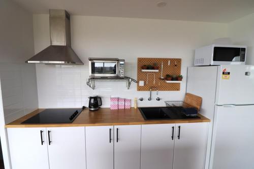 a kitchen with white cabinets and a white refrigerator at 4 Scenic Court in Mallacoota