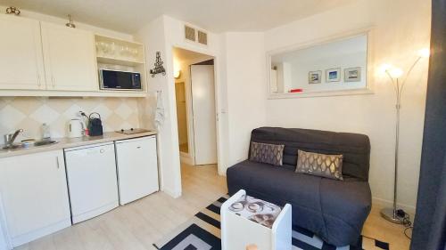 un salon avec un canapé et une cuisine dans l'établissement Les Félibriges, à Cannes