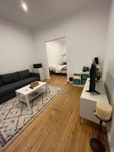 un soggiorno con divano e tavolo di studio indépendant sans cuisine - Le coin cosy avec WIFI a Bruxelles