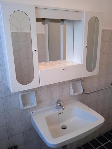 ein Badezimmer mit einem weißen Waschbecken und einem Spiegel in der Unterkunft Il Cortile in Brugherio
