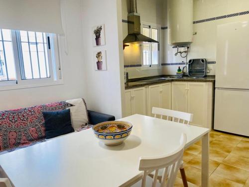 una cocina con una mesa blanca con un tazón. en Apartamentos Rubio, en Chipiona