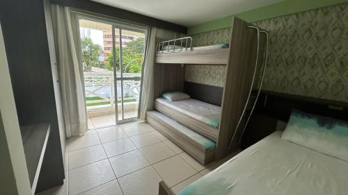 a small room with two bunk beds and a window at Apartamento Imperial Porto Brasil in Pirangi do Norte