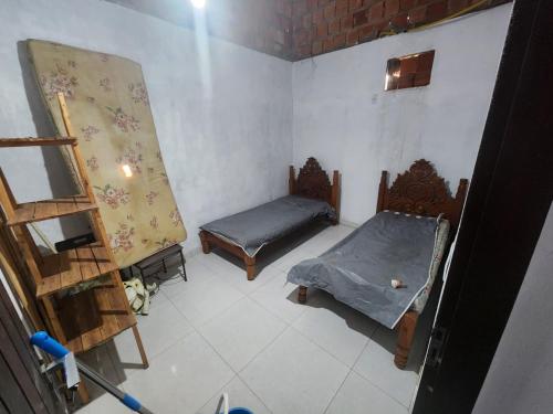 Zimmer mit 2 Betten und Wandgemälde in der Unterkunft Mini Chácara Cristo Redentor in Marechal Deodoro