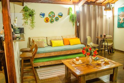 a living room with a couch and a table at CHALÉ ADOBE in Carrancas