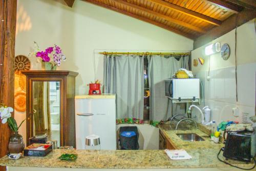 a kitchen with a refrigerator and a counter top at CHALÉ ADOBE in Carrancas