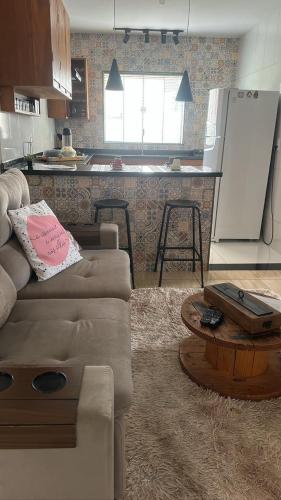 uma sala de estar com um sofá e uma cozinha em Cantinho Feliz - Próximo ao Centro histórico em Tiradentes
