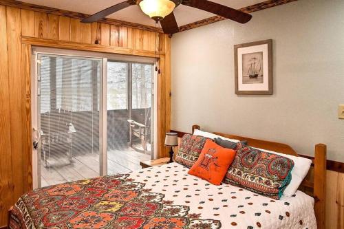 um quarto com uma cama e uma porta de vidro deslizante em Cozy lakefront cabin with boat house and ramp on T em Alliance