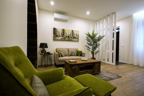 a living room with a green couch and a table at INNature in Ponta Delgada