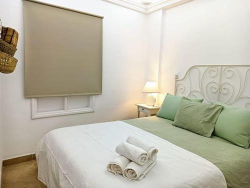 ein Schlafzimmer mit einem weißen Bett mit Handtüchern darauf in der Unterkunft Casa Martín in Puerto del Carmen