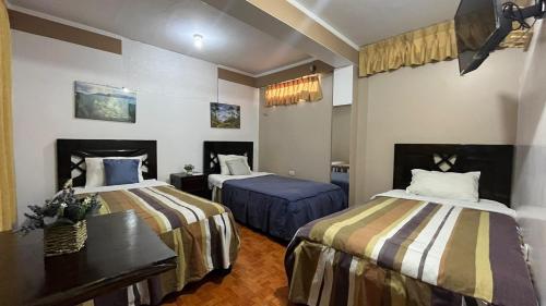 una habitación de hotel con 2 camas en una habitación en Waylla Hostel, en Huaraz