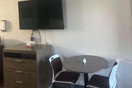 Camera con tavolo, sedie e TV di Econo Lodge Calhoun South a Calhoun