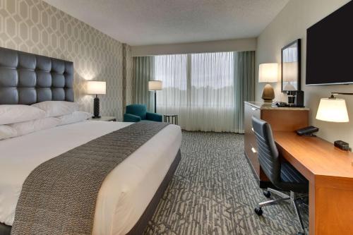 a hotel room with a large bed and a desk at Drury Plaza Hotel Richmond in Glen Allen
