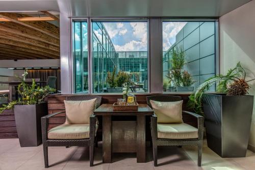 a table and chairs in a room with windows at Andersia Hotel & Spa Poznan, a member of Radisson Individuals in Poznań