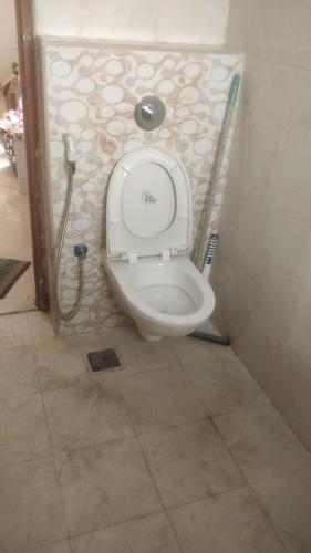 a bathroom with a toilet with the lid up at Gardenia Groove Villa, Ramky Discovery City in Maisaram