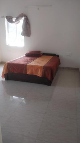 ein Schlafzimmer mit einem Bett in einem Zimmer mit einem Fenster in der Unterkunft Gardenia Groove Villa, Ramky Discovery City in Maisaram