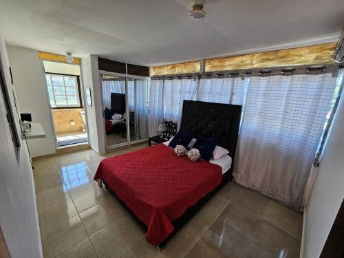 ein Schlafzimmer mit einem roten Bett mit einer roten Decke in der Unterkunft Penthouse con Jacuzzy en Santo Domingo in Cancino