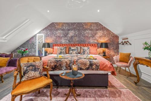 a bedroom with a large bed and two chairs at The Ley Arms in Exeter