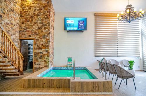 einen Pool in einem Wohnzimmer mit einem Tisch und Stühlen in der Unterkunft La Ocotera Hotel de montaña Cabañas Amenidades in San Marcos