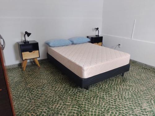 een slaapkamer met een bed en twee nachtkastjes bij Departamento Jorge in Marcos Juárez