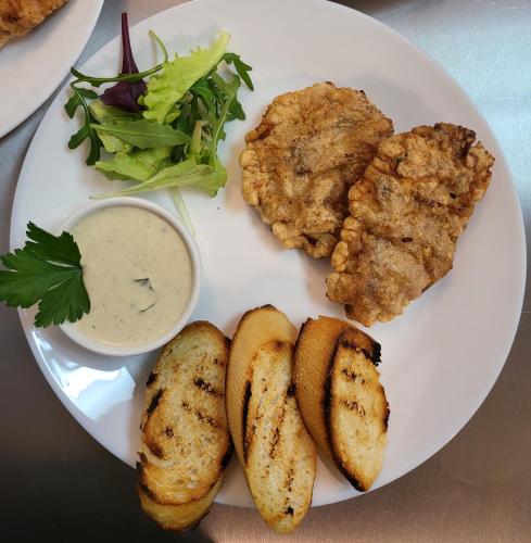a plate of food with meat and a salad and dipping sauce at Adac Boutique Hotel in Bucharest