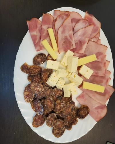 a plate of food with meat cheese and meats at Adac Boutique Hotel in Bucharest