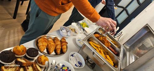 a person reaching for a tray of food at a buffet at Adac Boutique Hotel in Bucharest