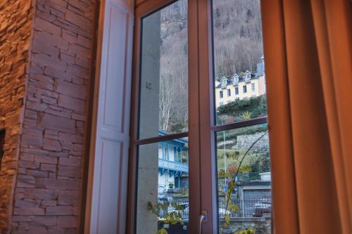 une fenêtre ouverte avec vue sur un bâtiment dans l'établissement L'Écrin - 76m2 - 8P - Centre Ville Cauterets, à Cauterets