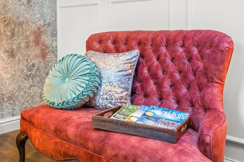 a red couch with a book and a pillow on it at The Ley Arms in Exeter