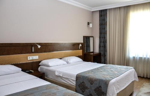 a hotel room with two beds and a window at Perla Hotel in Dikili
