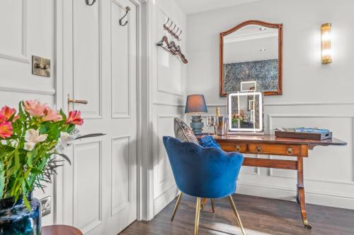 a desk with a blue chair and a mirror at The Ley Arms in Exeter