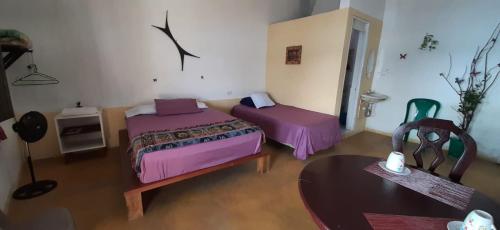a room with two beds and a table and a chair at Habitación Privada Doña Zoila in Flores