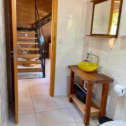 a bathroom with a yellow sink and a staircase at Villetta Gramado Florença in Gramado