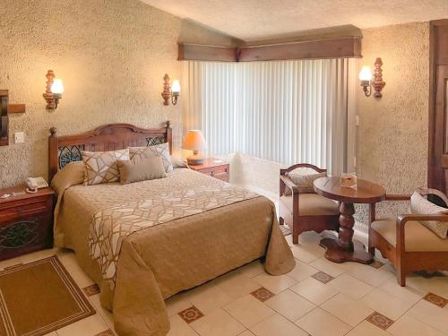 a bedroom with a large bed and a table and chairs at Villas Layfer, Córdoba, Veracruz, Mexico in Córdoba