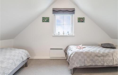 a attic bedroom with two beds and a window at 3 Bedroom Beautiful Home In Brenderup Fyn in Bro
