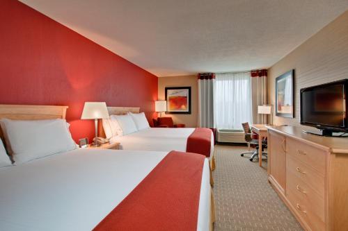 a hotel room with two beds and a flat screen tv at Holiday Inn Express Hotel & Suites Chatham South, an IHG Hotel in Chatham